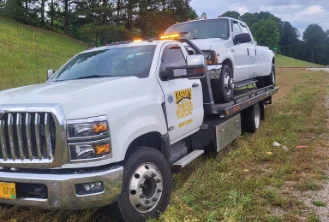 Jason's Wrecker Service's International rollback with a dually pickup loaded and strapped on the deck