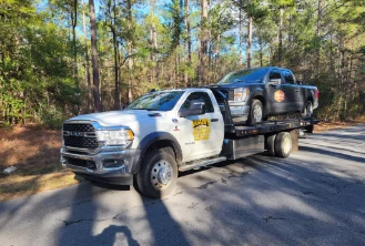 Jason's Wrecker Service's Ram rollback with a dark pickup loaded on the deck